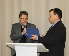 Irineu Munhoz, presidente do Sima lê placa de agradecimento ao deputado Cobra